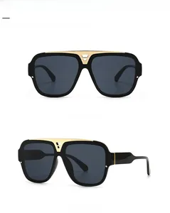 Detail der quadratischen Übergroßen Sonnenbrille mit goldenen V-Metallteilen und Gläsern
