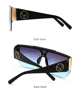 Detail of oversized sunglasses showing gold deer emblem on wide black temples