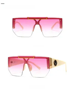 Detail of oversized square sunglasses with beige frames, pink lenses, and deer logo