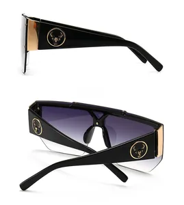 Detail of modern oversized sunglasses with gold deer logo and gradient purple lenses