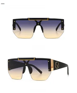 Detail of square oversized sunglasses with gold reindeer logo and gradient lenses