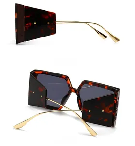 Detail view of square tortoiseshell sunglasses featuring golden hollow metal side temple