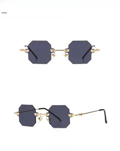 Detail view showing rimless gold metal sunglasses with dark grey polygonal lenses