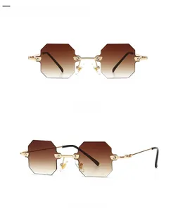 Close-up of rimless octagonal sunglasses with gold metal frame and gradient tan lenses