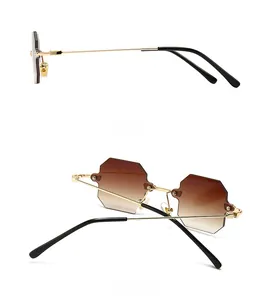 Detail view of square rimless sunglasses with brown gradient lenses and gold metal frame