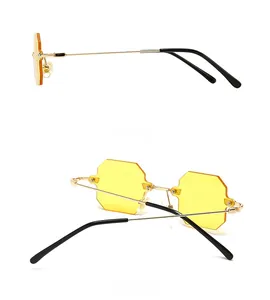 Detail view of octagon yellow sunglasses with slim gold metal frames and black tips