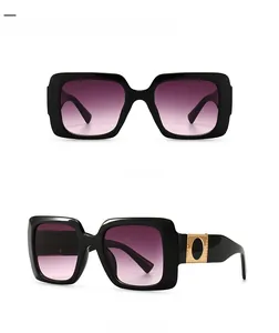 Detail view of square black sunglasses with golden hardware and violet pink gradient lenses