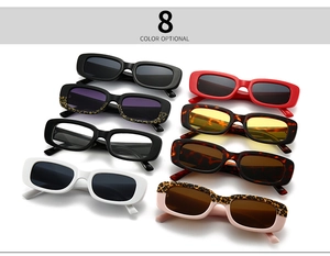 Flat lay of eight colorful rectangular retro sunglasses in various colors on white background