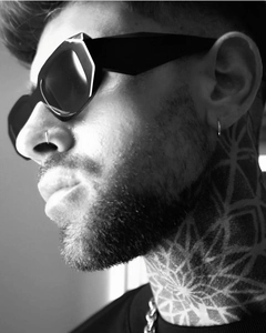 Close-up of black retro square sunglasses on model with mandala neck tattoo detail