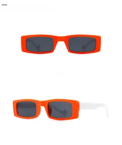Close-up of retro narrow rectangular sunglasses in bold orange frames with white temples