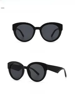 Détail de lunettes de soleil noires surdimensionnées avec monture texturée et verres gris