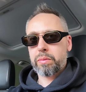 Moderne rechteckige Sonnenbrille mit schwarzem Rahmen und goldenem Steg im Auto
