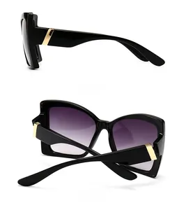 Detail view of square black sunglasses with gradient purple lenses and gold metal accents