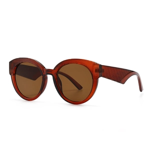 Lunettes de soleil rétro ambre avec texture rayée et verres marron sur fond blanc épuré