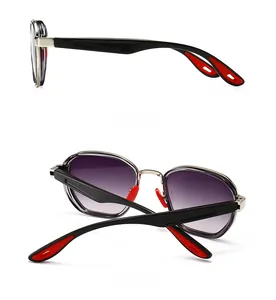 Detail view of modern square sunglasses featuring gradient lenses and red accents