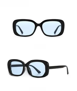Détail de lunettes de soleil ovales rétro avec monture noire et verres bleu clair