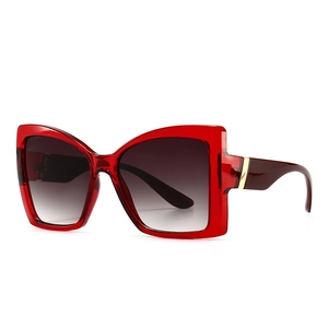 Modern oversized cat-eye sunglasses with translucent red frames and gradient lenses