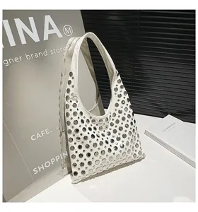 Detail of white Hobo bag featuring silver metal rivets and avant-garde punk style design