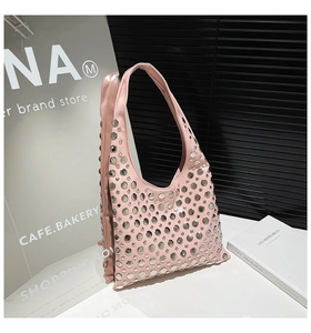 Detail showing pink hobo bag with silver round rivets and smooth leather texture