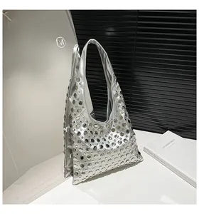 Macro detail of metallic silver tote bag featuring dense round rivet studs and punk style