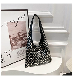 Detail of silver rivets on black gothic shoulder bag with smooth synthetic leather texture