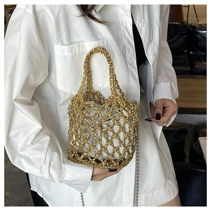 Detail einer goldenen Netztasche mit weißem Kordelzugfutter und feiner Metallkette