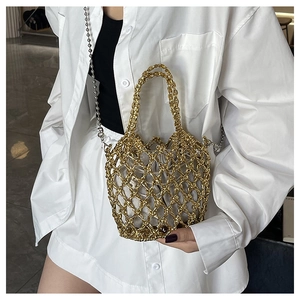Nahaufnahme einer goldenen Netztasche aus Metall mit grauem Innenfutter und Perlenkette