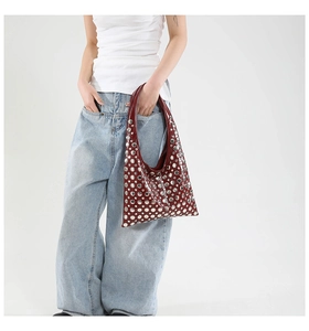 Model wearing a wine red punk hobo bag with large silver studs and metallic finish