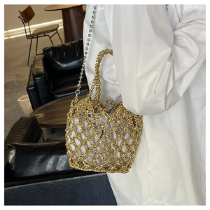 Detail der goldfarben gewebten Handtasche mit Kordelzugbeutel und silberner Perlenkette