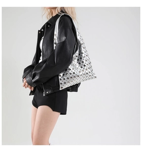 Close-up of metallic silver shoulder bag with decorative metal rivets and punk style