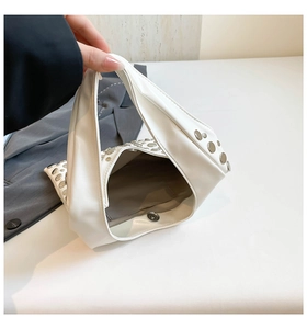 Interior view of white studded bucket bag showing magnetic clasp and dark fabric lining
