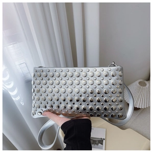 Close-up of a silver rectangular clutch bag featuring dense metallic rivet studs