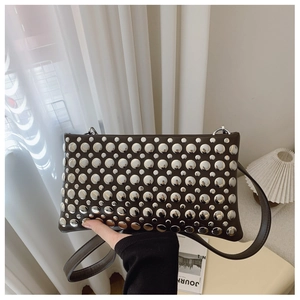 Close-up of a brown shoulder bag with metallic silver studs and sleek synthetic leather