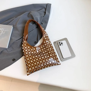 Brown faux leather hobo bag with silver studs and wide strap for daily commuting