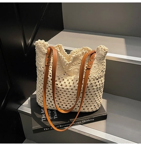 Detail of cream crochet tote bag featuring scalloped edges and brown leather handles