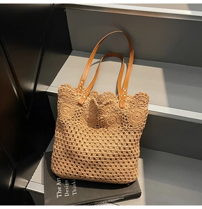 Close-up of crochet weave texture and brown leather handles with gold rivets on tote bag