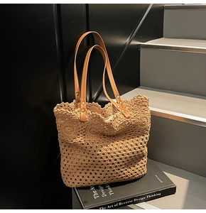 Detail of crochet tote bag featuring geometric hollow patterns and brown leather handles