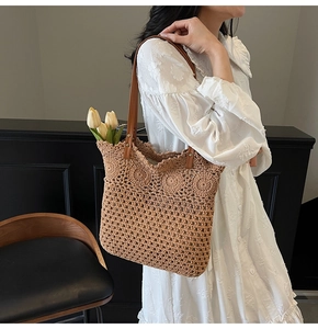 Detail of hand-crocheted tote bag with 3D floral accents and sleek brown shoulder strap