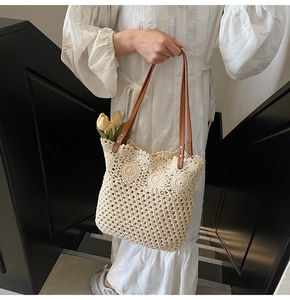 Detail of hand-woven cream crochet tote bag with brown leather straps and floral design