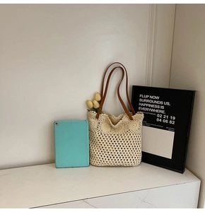 Detail of crochet tote bag with flower pattern, brown leather handle and rivet accents