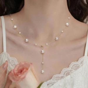 Detailed view of 925 silver Y-shape pearl necklace with cascading white beads on a model