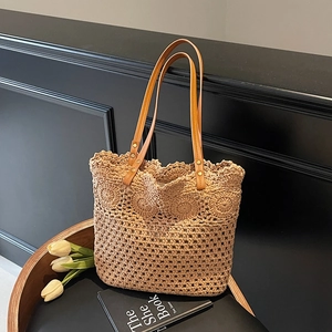 Handmade crochet tote bag with brown leather handles on a vintage chair