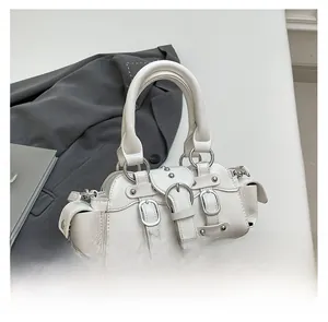 Gros plan détaillé du sac Boston en cuir blanc avec clous et ferrures argentées