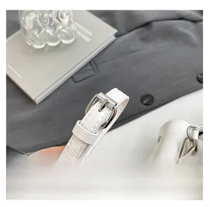 Gros plan sur la bandoulière réglable en cuir PU blanc avec boucle argentée et texture