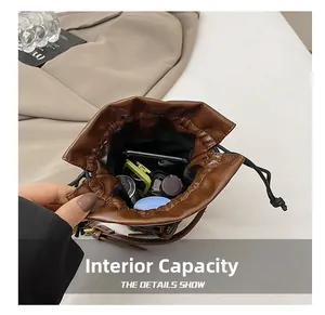Detail view of the deep brown leather bucket bag internal capacity and drawstring closure