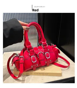 Détail du sac Boston en cuir verni rouge avec boucles argentées et rivets de style punk