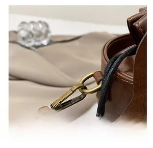 Detail of vintage bronze swivel hook on brown leather bucket bag with quality stitching