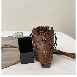 Detailed view of the brown leather horse head mask bucket bag with brass flower studs