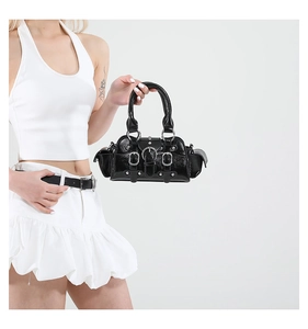 Gros plan du sac à main en cuir verni noir brillant avec clous et boucles argentés