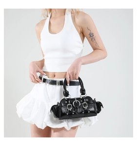 Détail du sac à main en cuir verni noir brillant avec fermetures éclair et rivets argentés